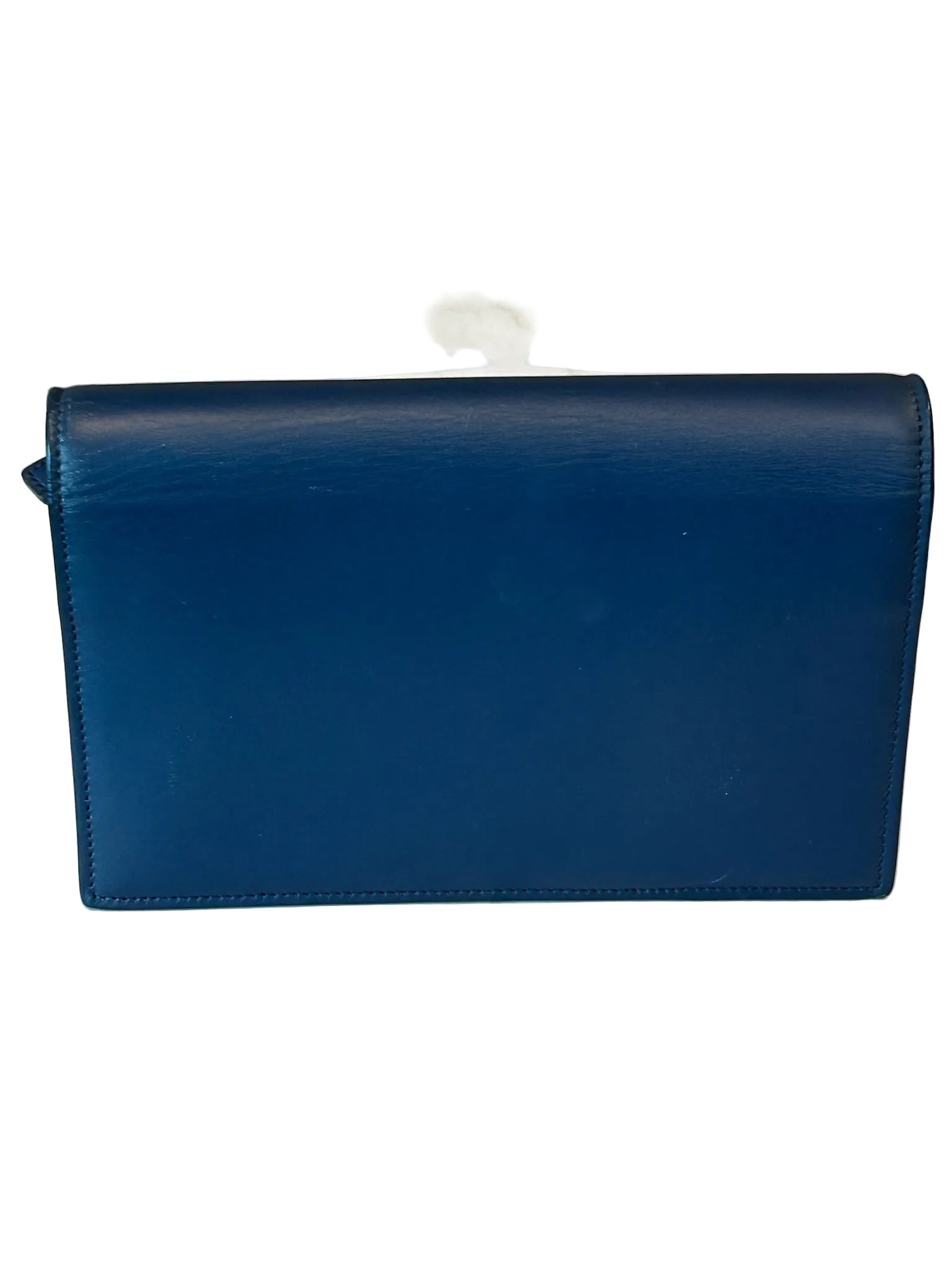 Blue leather clutch bag on a white surface with a neutral background