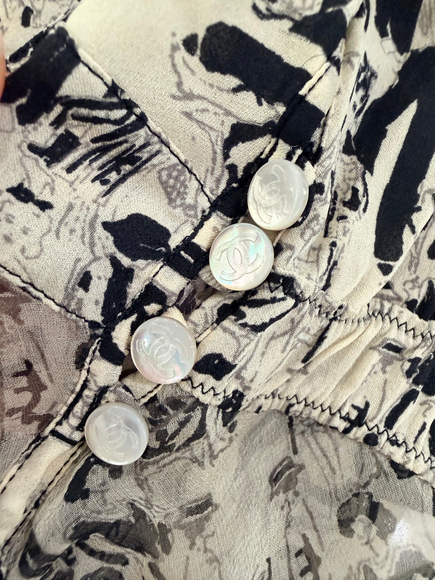 Chanel vintage 03P CC logo tunic top features a white and black silk print with a ruffled frill